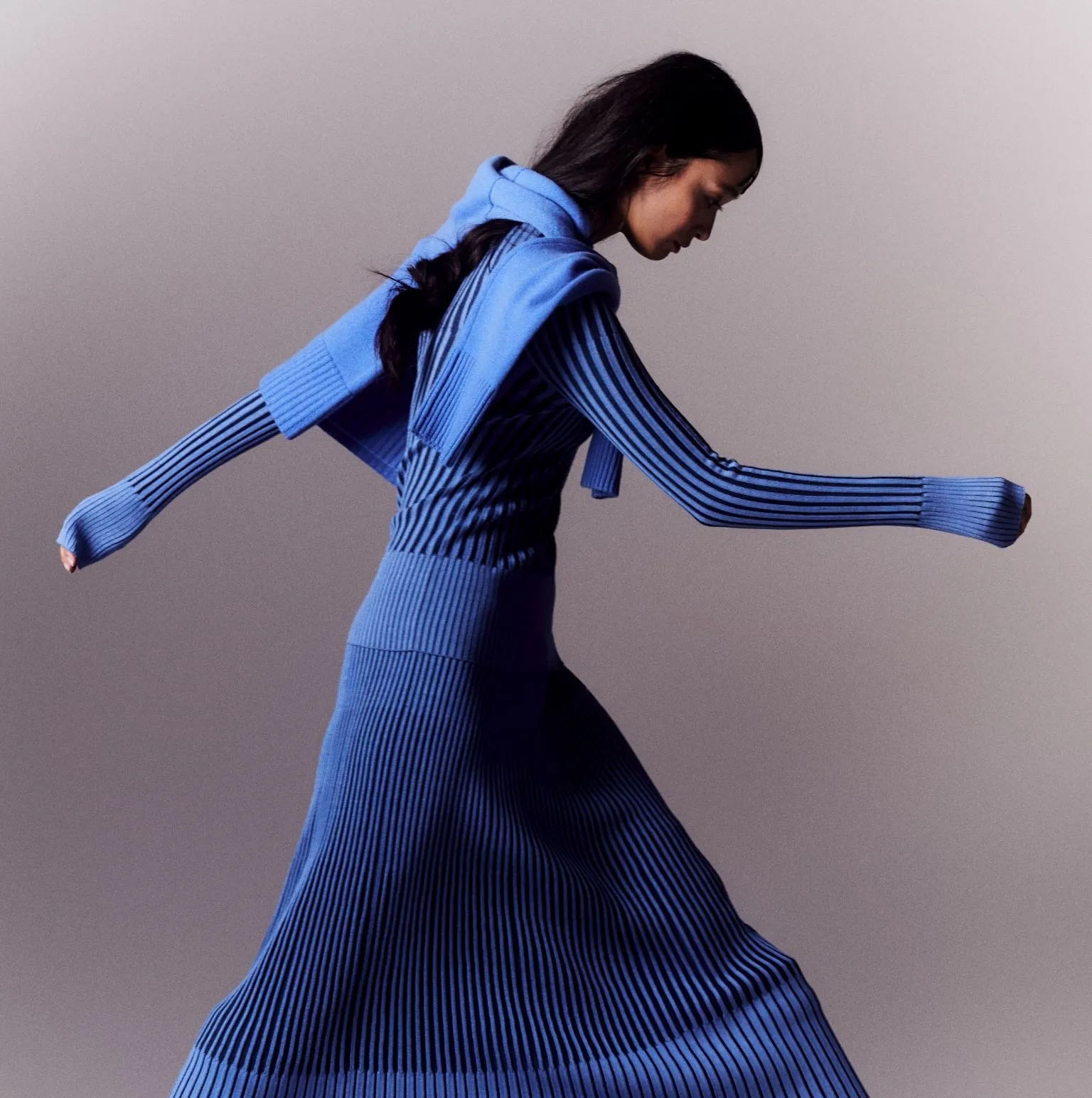 Model in a blue ribbed-knit dress